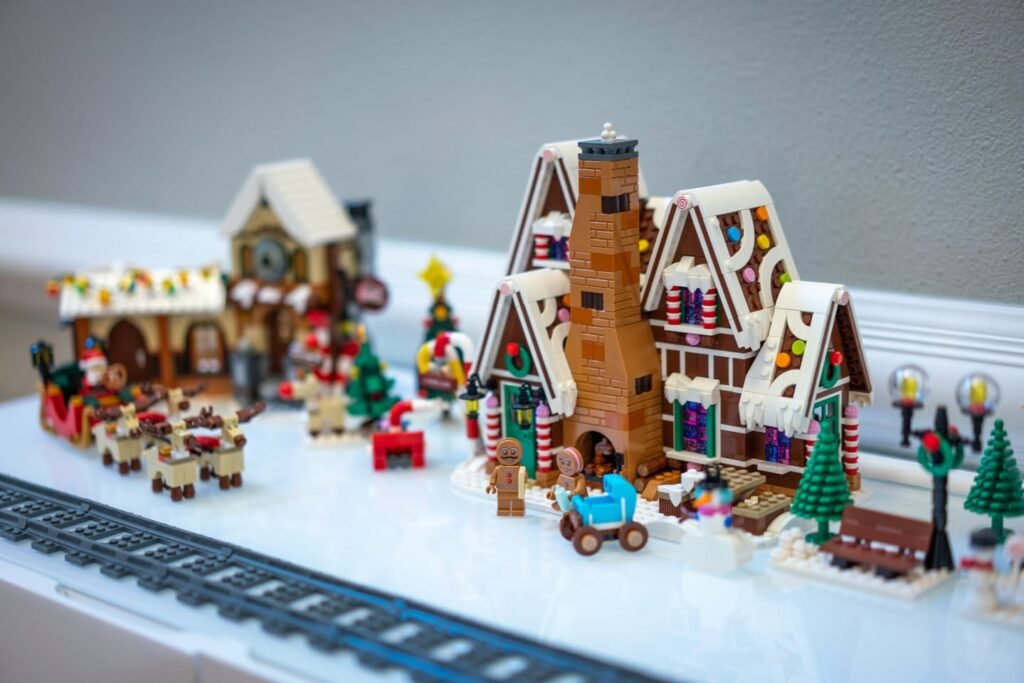 A festive LEGO diorama featuring snowy buildings, holiday decorations, and model trains.