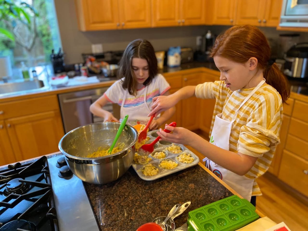 Twin Chefs Two children bake cookies in a home kitchen with wooden cabin.