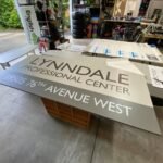 A sign for the Lynndale Professional Center at 19935 76th Avenue West is displayed on a wooden crate.