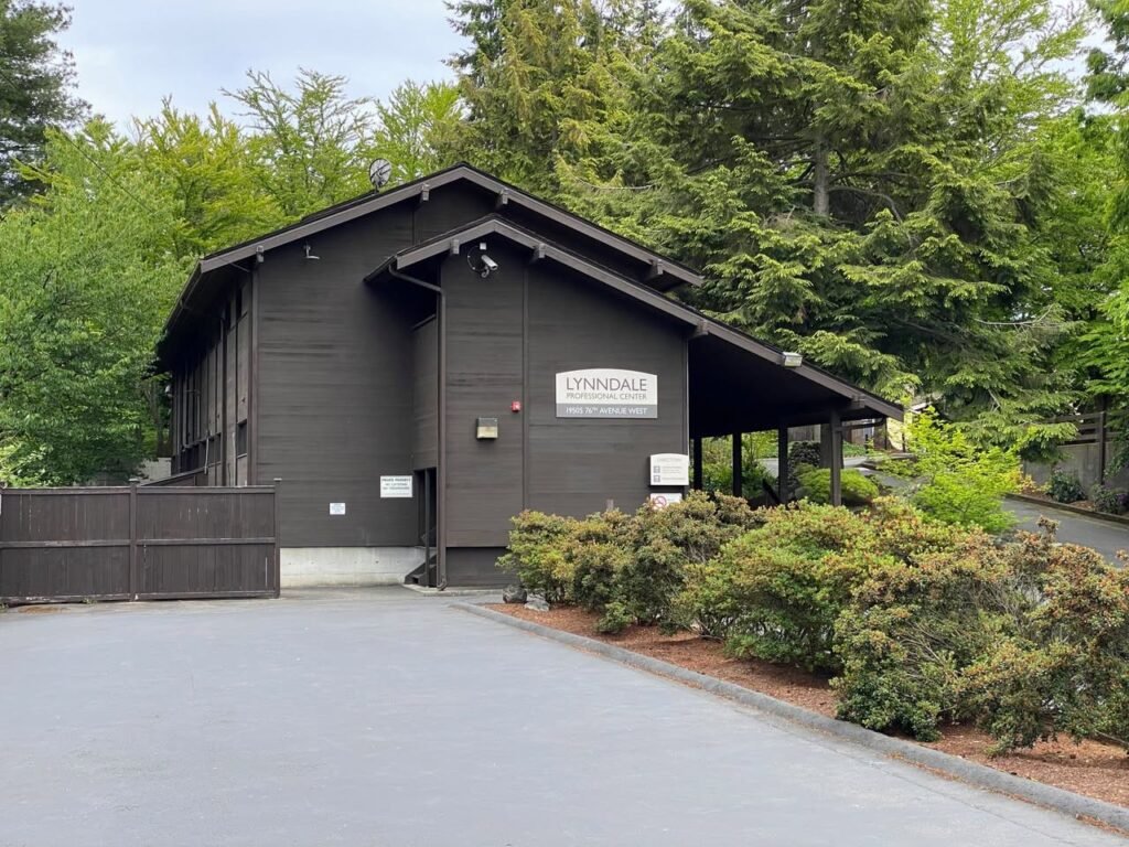 A large building for the entrance of The Blooms at Japanese Style Landscape in Portland, Oregon, surrounded by green shrubs and dense forests.