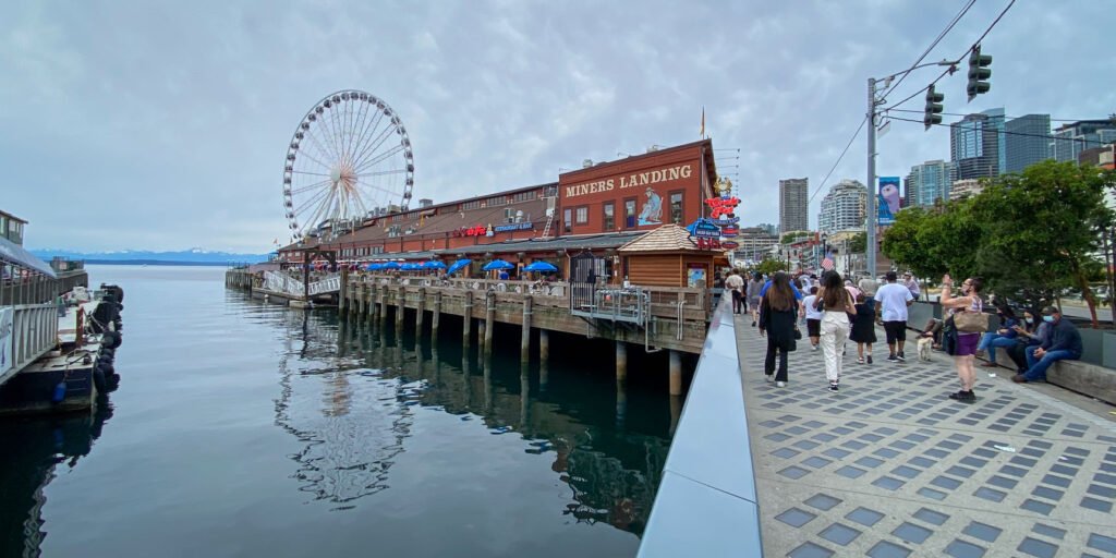 Two views of the Seattle waterfront featuring the Great Wheel and Pike Place Market structures.