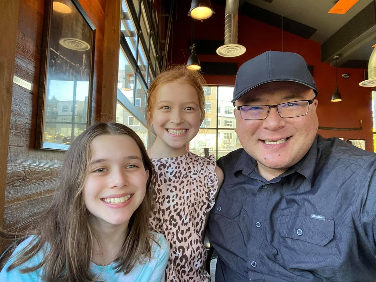 A family of three taking a selfie at a restaurant. The image shows a montage of views in a modern eatery.