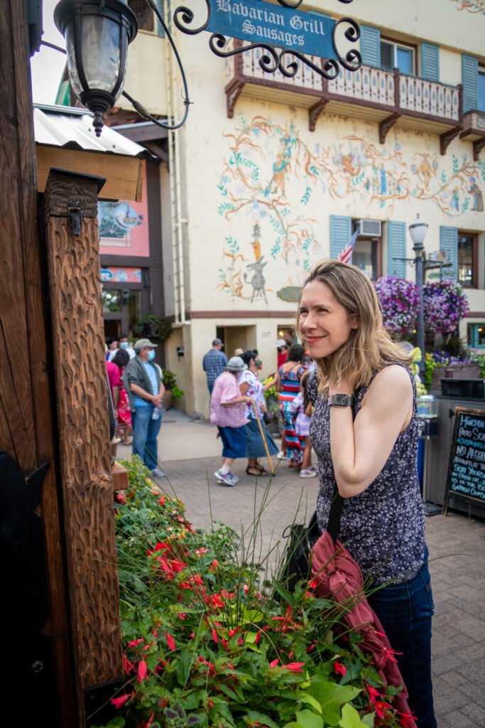 A vibrant city street with a colorful mural featuring a woman and various pedestrians.