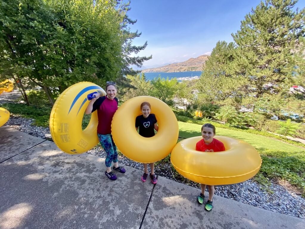 Family enjoying summer fun with inflatable yellow rings at Lake Coeur d'Alene.