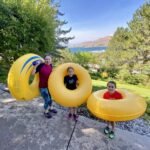 Family enjoying summer fun with inflatable yellow rings at Lake Coeur d'Alene.