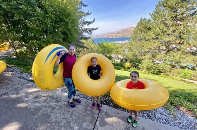 Family enjoying summer fun with inflatable yellow rings at Lake Coeur d'Alene.