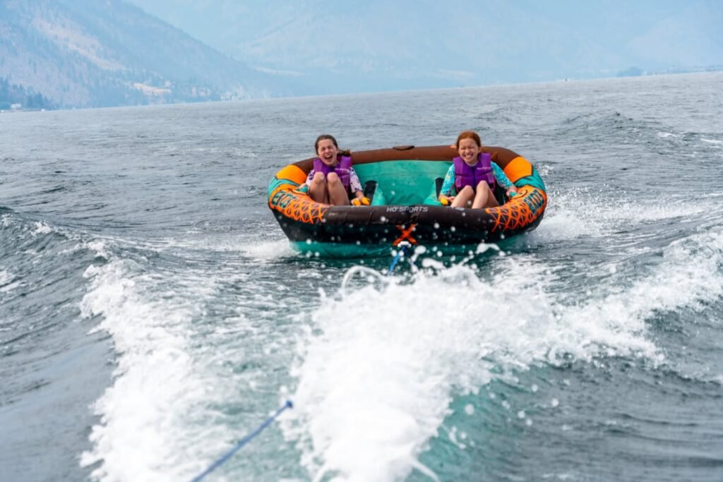 Tubing behind a boat on a lake in the Pacific Northwest, creating a large wake.