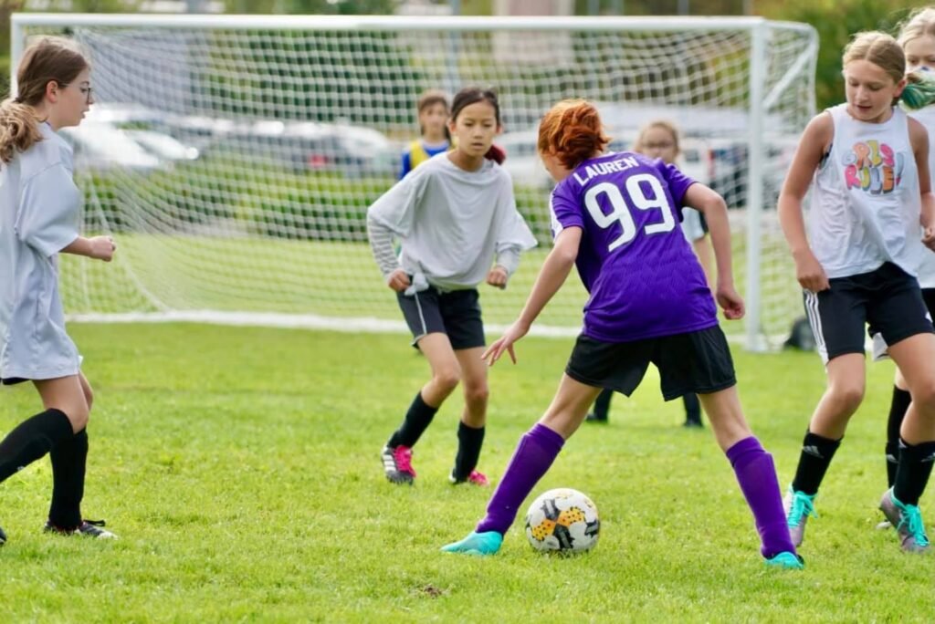 A collage of photos showing a youth soccer game in progress on a grassy field, featuring young players in purple and white jerseys competing for the ball near the goal.
