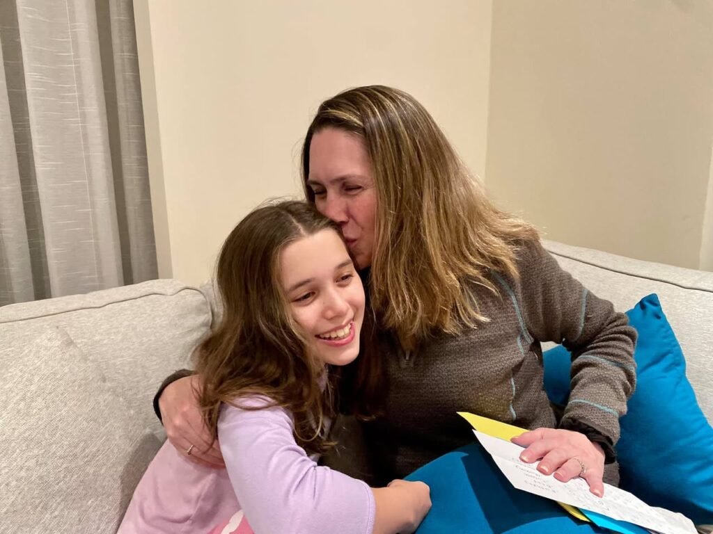 Two people share a warm and loving moment on a beige couch, smiling and having fun together.