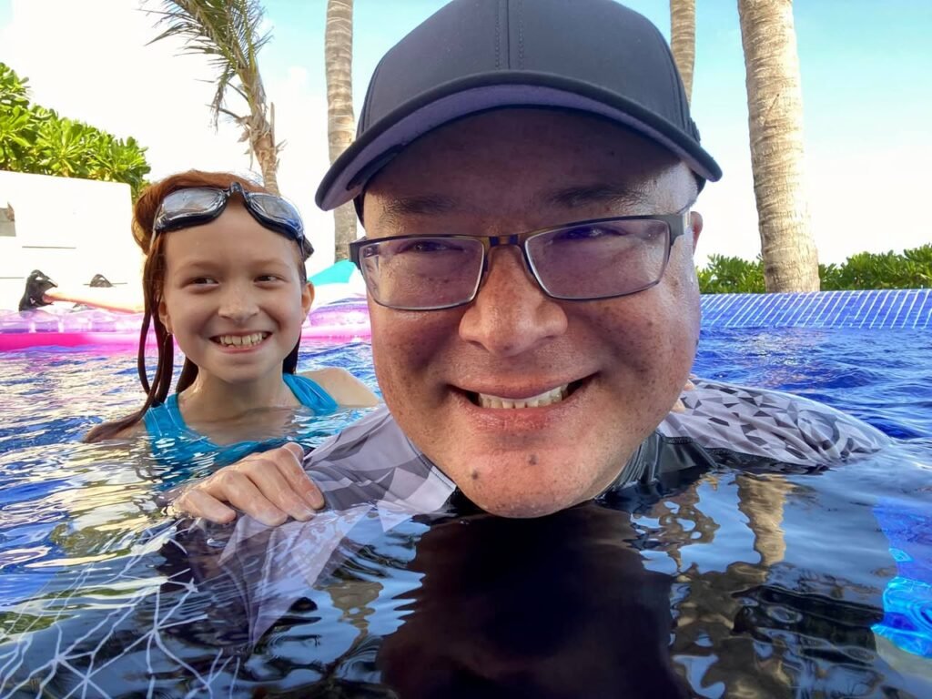 Enjoying summer pool time with a smile. Tropical palm trees in the background.