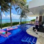 Xcaret Theme Park A sunny day at a resort with a pool and palm trees overlooking the ocean.