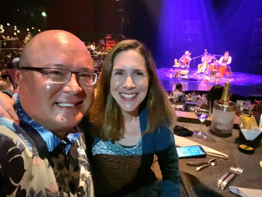 A smiley couple enjoying a concert night at an outdoor venue.