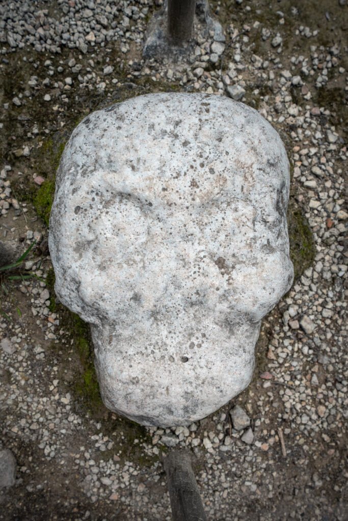 A close-up view of a smooth white granite stone resting on a bed of coarse gravel and earth.