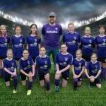 Coba Ruinas Arqueológicas A youth soccer team in purple uniforms poses for a group photo on a grassy field with stadium lights in the background. A team photo in purple soccer uniforms at a stadium backdrop.