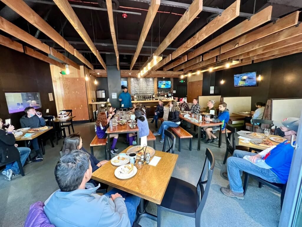 A rustic indoor restaurant with wooden beams and patrons dining.