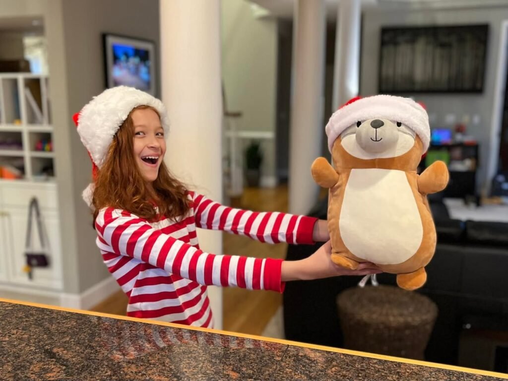 A joyful moment with a child in festive pajamas holding a matching plush bear at home.