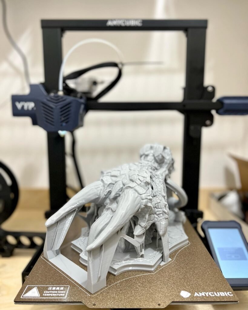 A completed figure from an Artcubic 3D printer, shown in multiple angles with close-ups of the build plate. The fantasy character statue is detailed and white.