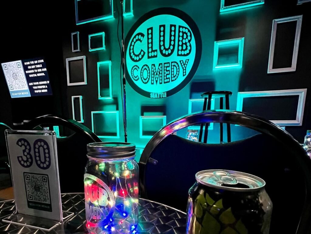 A table at Club Comedy Seattle with a drink can and lighted glass jar, table number 30.