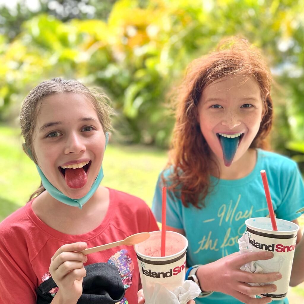 Enjoying colorful Iceland Snow Cones at a park with playful duck faces. A fun family moment from our travels.
