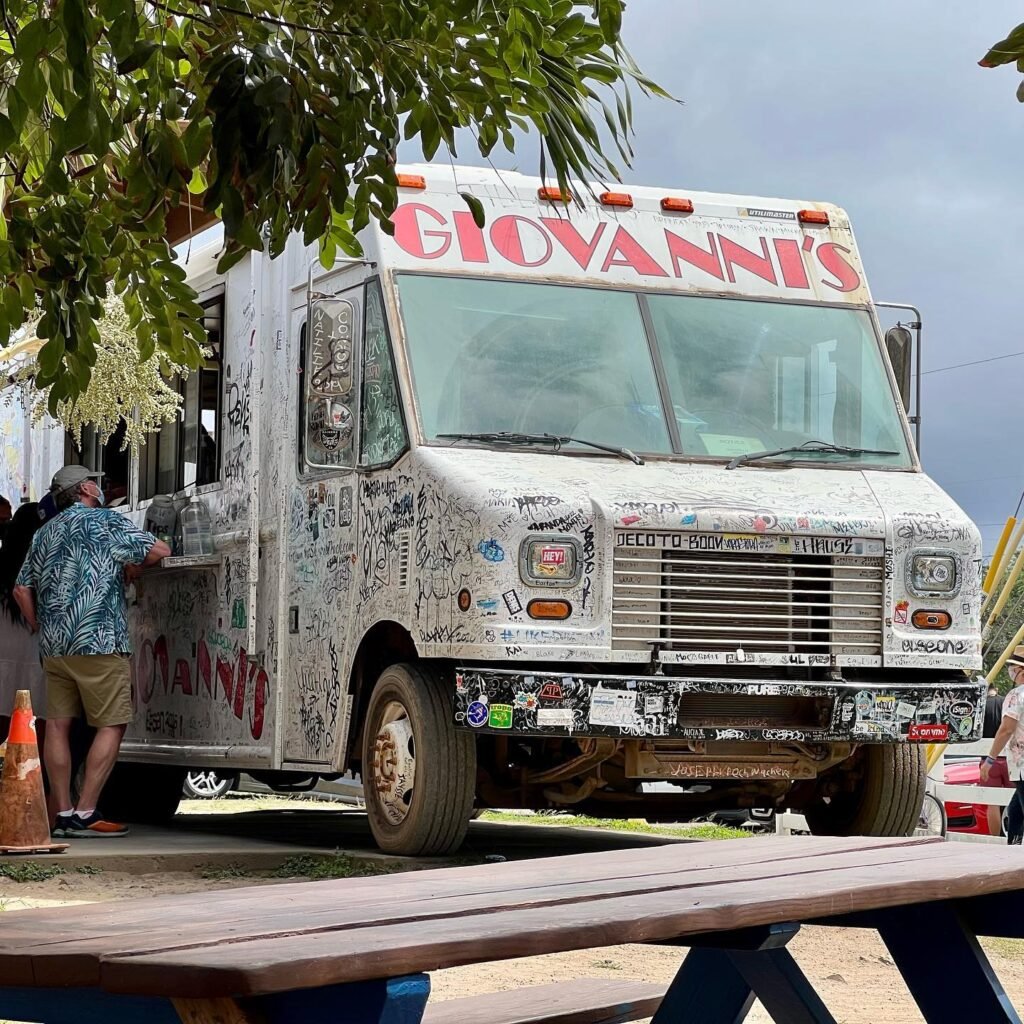 A close-up of the Giovanni's ice cream truck, complete with a wooden picnic table in the foreground.