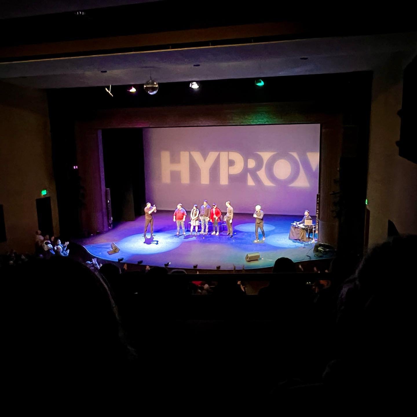 View of a HYPROX live performance on stage. The scene is captured from the audience perspective.