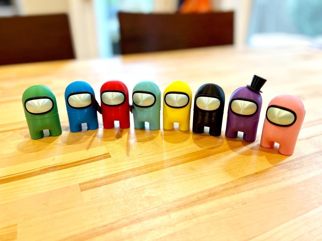 Among Us Row of colorful, egg-shaped characters on a wooden table.