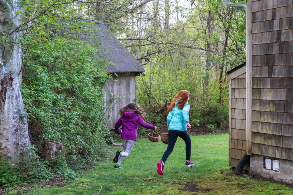 A joyful Easter egg hunt in a lush garden surrounded by trees. Family fun on a scenic day outdoors.