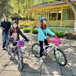 Bounce Around Two girls on bicycles and one adult ride through The Enchanted Forest in Pacific Grove, California.