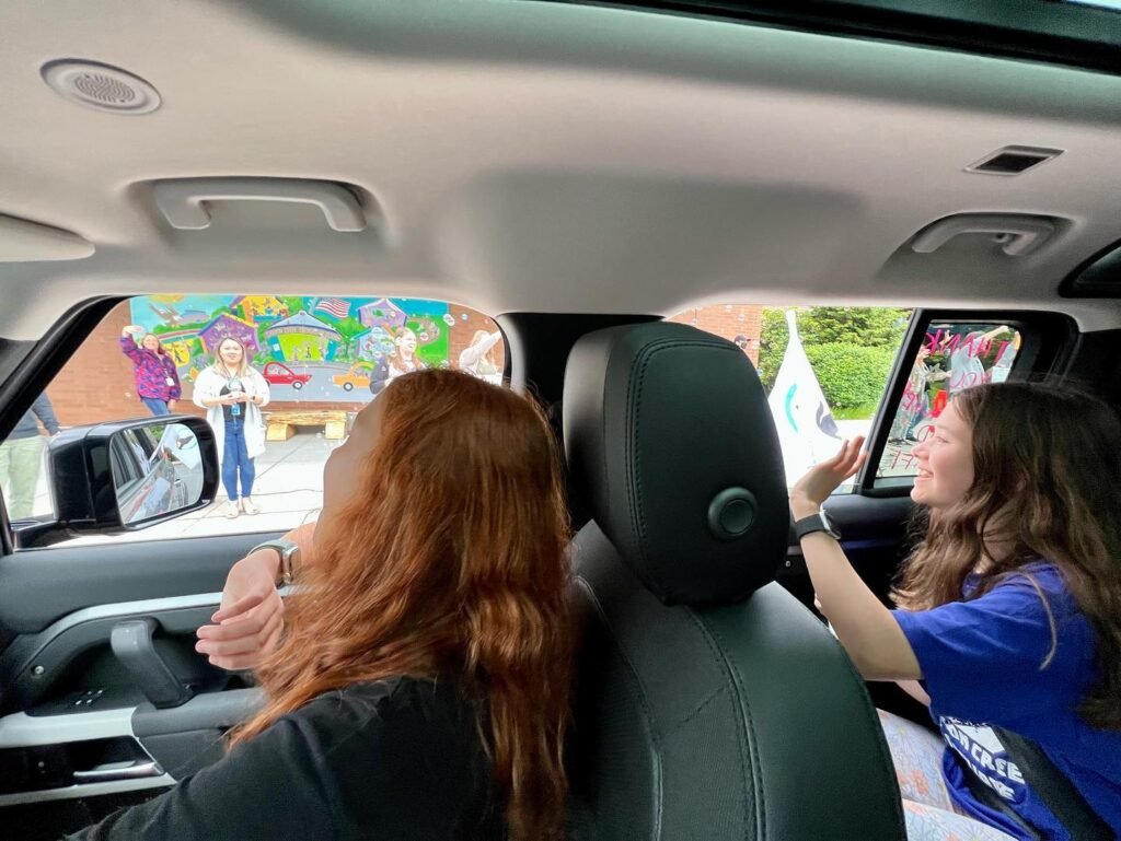 Passengers view a colorful outdoor scene from a vehicle, capturing details of the car interior and bright exterior.