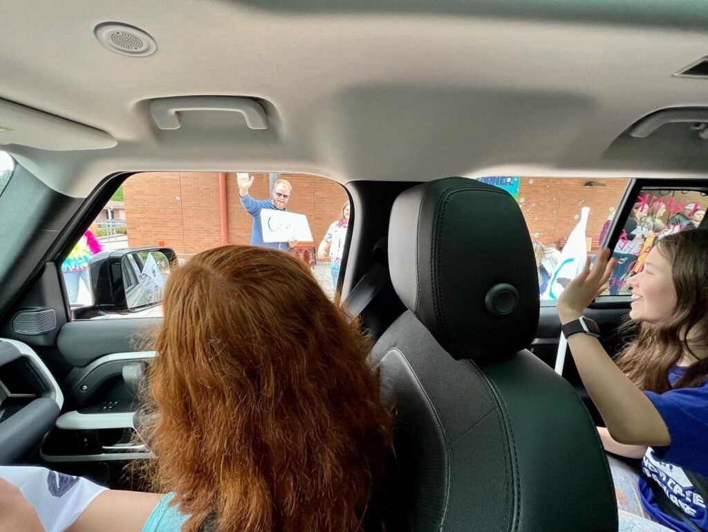 A view from inside a car during a family road trip, with people seated in the back looking out the windows.