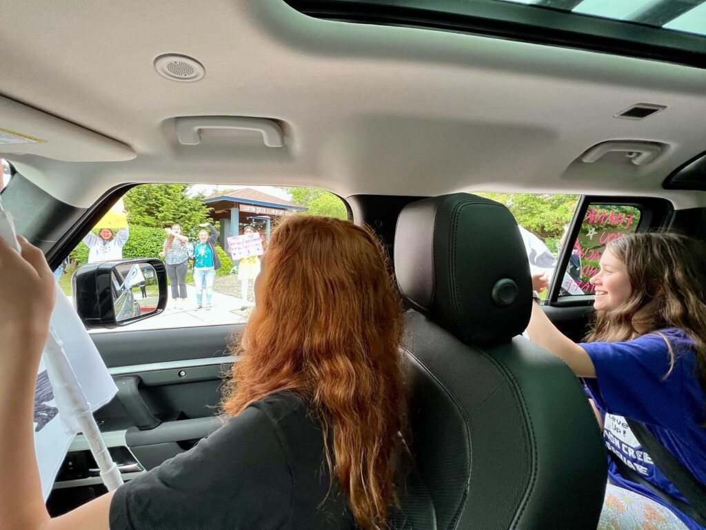 A view from inside a van with a sunroof looking out at people on the street during a summer road trip.