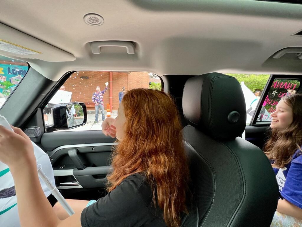 Passengers in a car looking out the window during a trip.