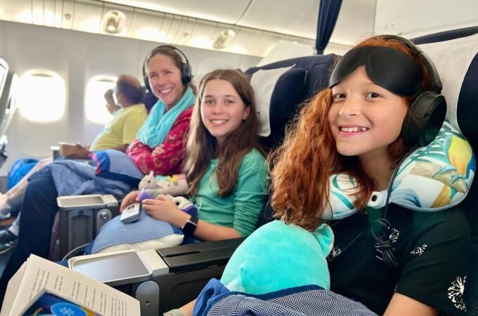 A family enjoys their flight with headsets and travel pillows.