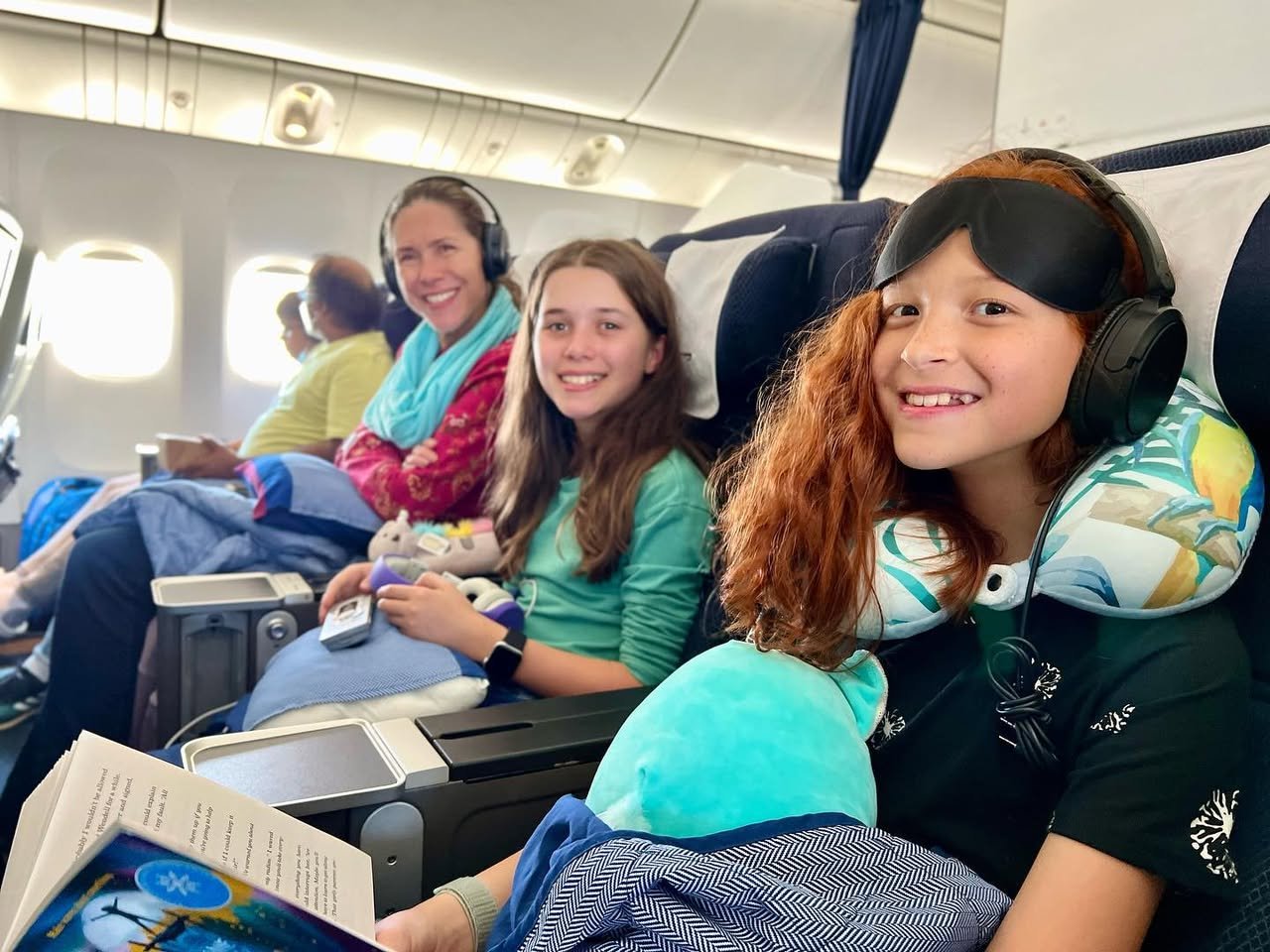 Arriving in London A family enjoys their flight with headsets and travel pillows.
