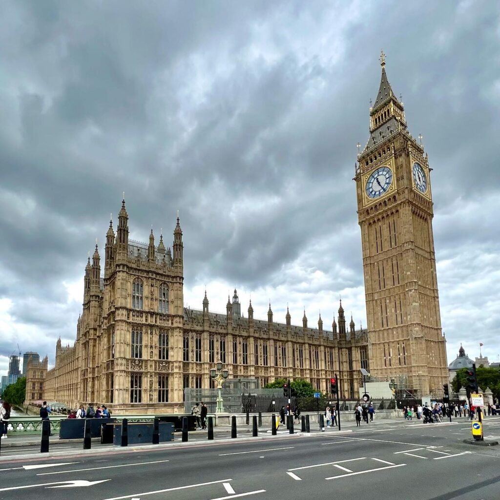 A view of the Palace of Westminster and Elizabeth Tower in London under overcast skies.