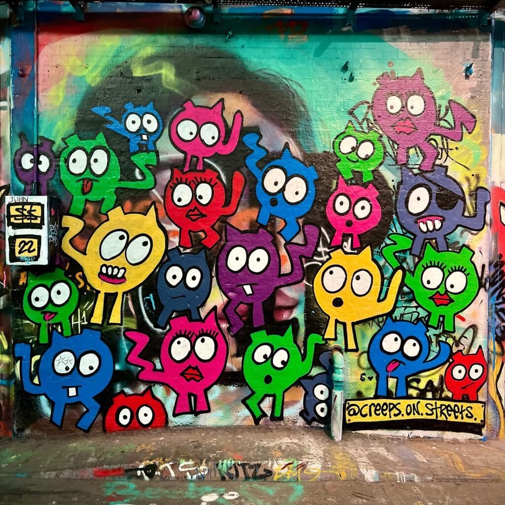 Colorful graffiti mural featuring cartoon characters creating a vibrant street art display in urban setting.