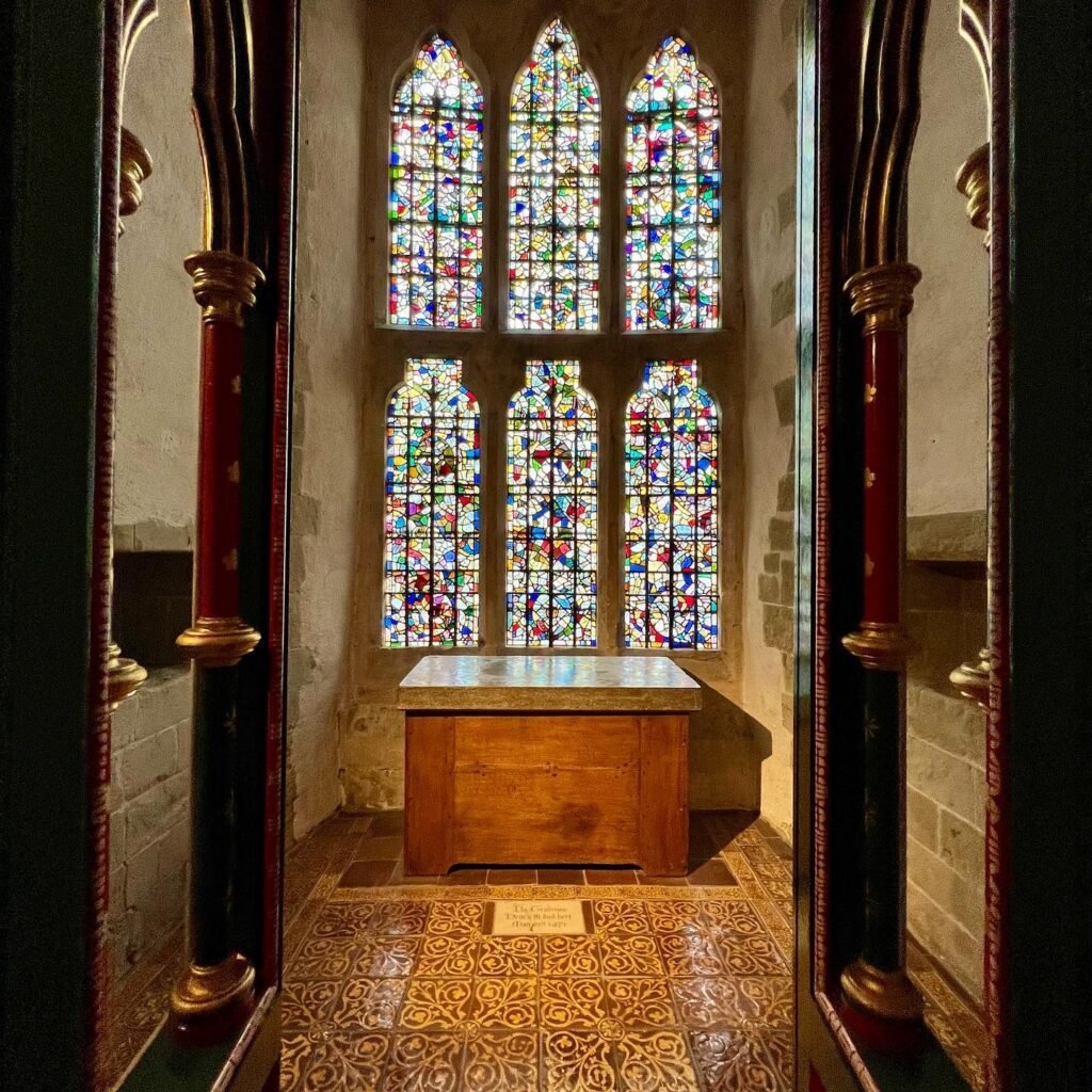 Beautifully crafted stained glass windows in a historic gothic-style corridor.