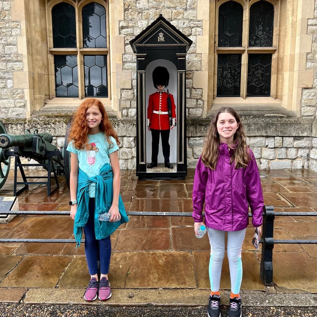 Group and individual shots of travelers in front of Windsor Castle's historic stone architecture.