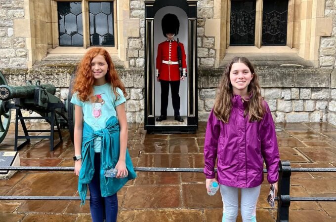 Group and individual shots of travelers in front of Windsor Castle's historic stone architecture.