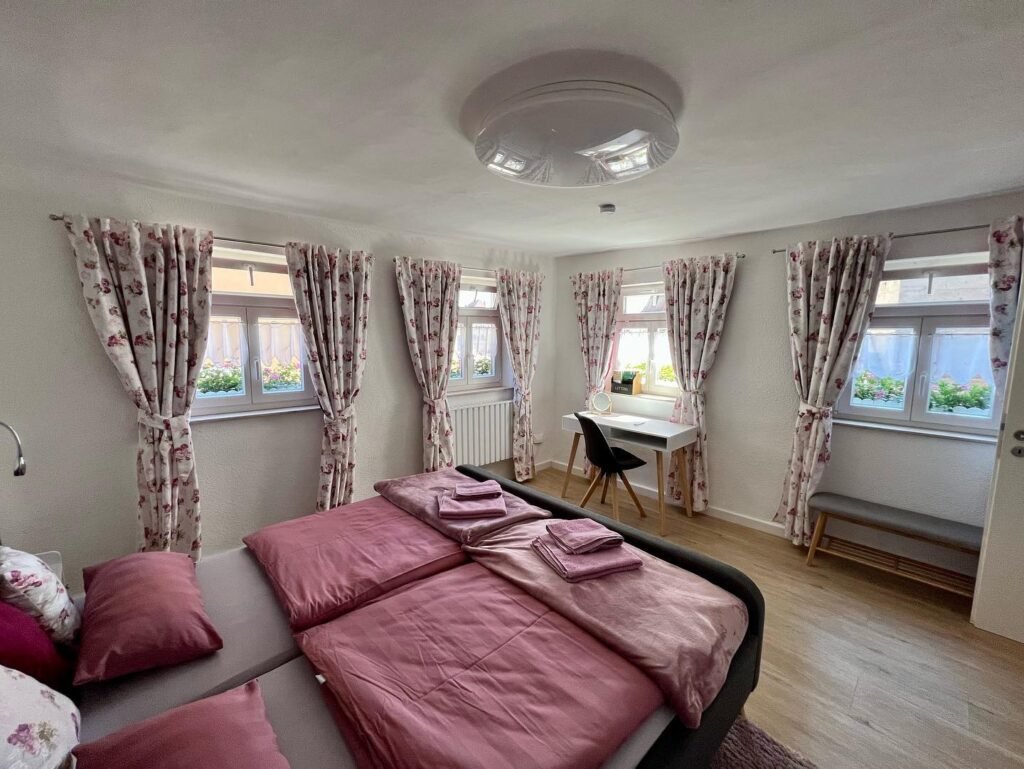 Cozy Room with Pink Linens and Floral Curtains