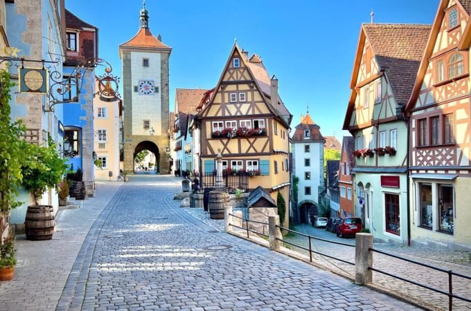 A scenic view of traditional European architecture featuring cobblestone streets and colorful half-timbered buildings.
