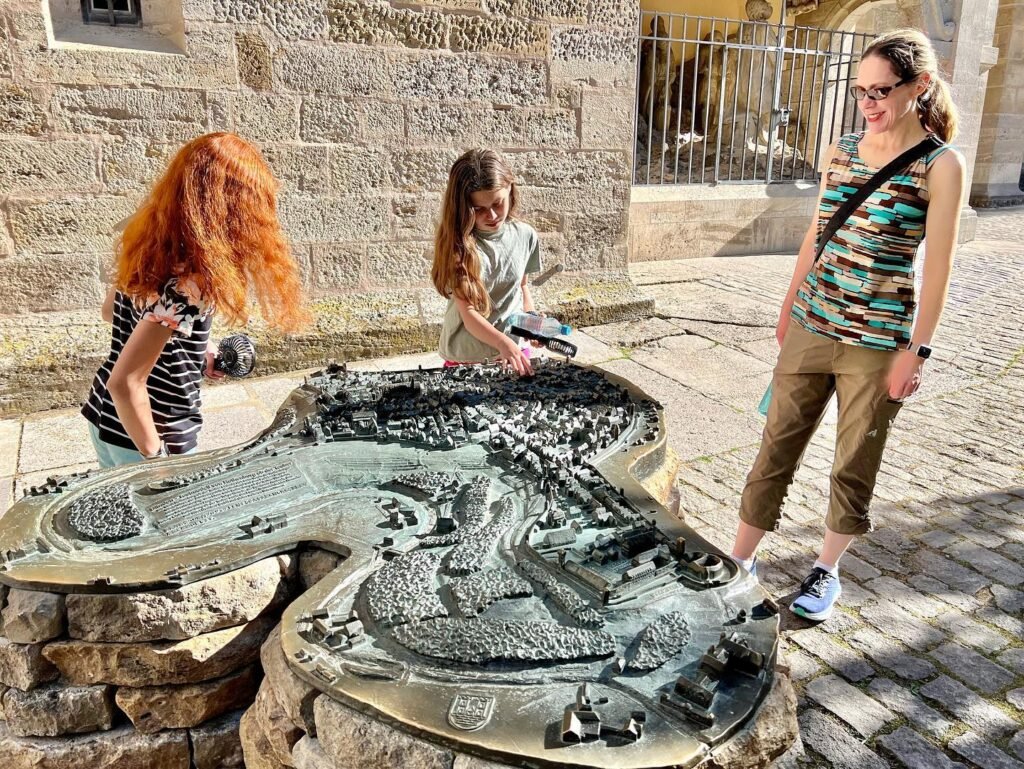 Visitors explore an outdoor sculptural map model.