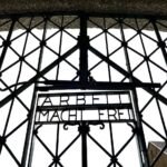Intricate lattice pattern of a wrought iron gate with bold lettering. Architectural detail from a travel photo on JohnandKristie.