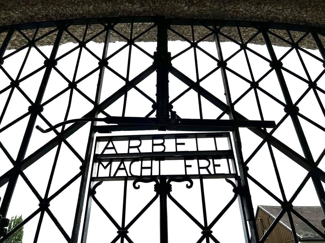 Dachau Intricate lattice pattern of a wrought iron gate with bold lettering. Architectural detail from a travel photo on JohnandKristie.