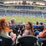 Stranger Things Stop Motion Friends and family enjoy a shared moment in the stands of a large outdoor stadium during a game.