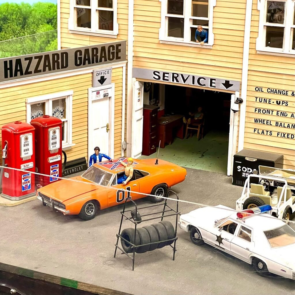A detailed miniature display of the Hazzard Garage with classic cars, seen during a family travel adventure in the Pacific Northwest.