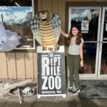 Big Finn Hill Park A visitor poses next to a large cobra statue and sign for The Reptile Zoo in Monroe, Washington.