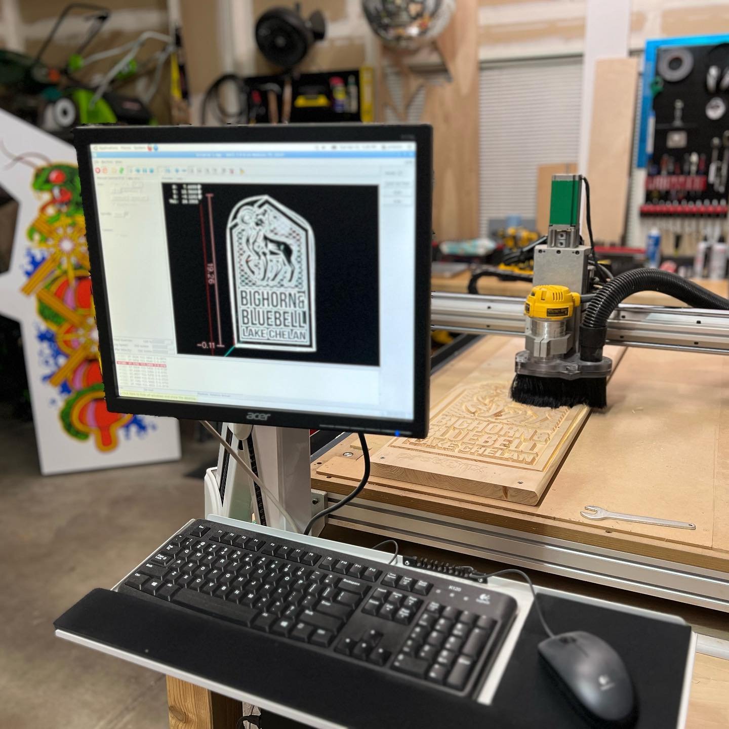 CNC router in a workshop with a computer displaying the design being cut.