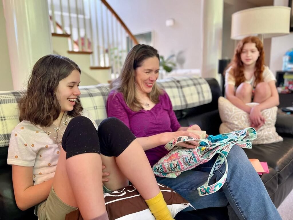 Three people relaxing on a couch in a cozy living room, sharing quality time together.