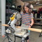 Volleyball A person wearing safety glasses uses a miter saw in a garage workshop. A close-up shows the blade and the edge of the wooden board being cut.